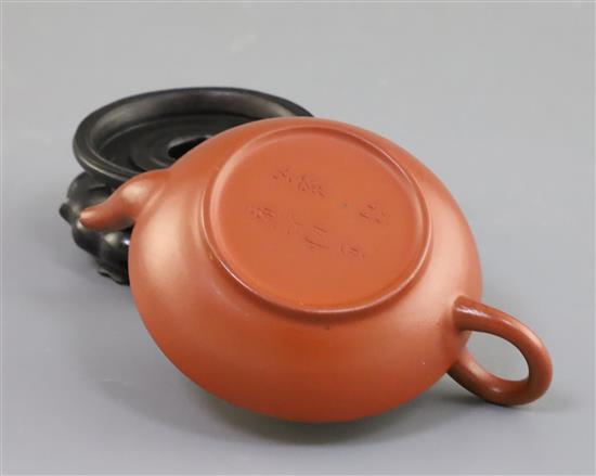 An inscribed Yixing teapot, late 19th/early 20th century, 10.2cm across, wood stand, small chip to spout